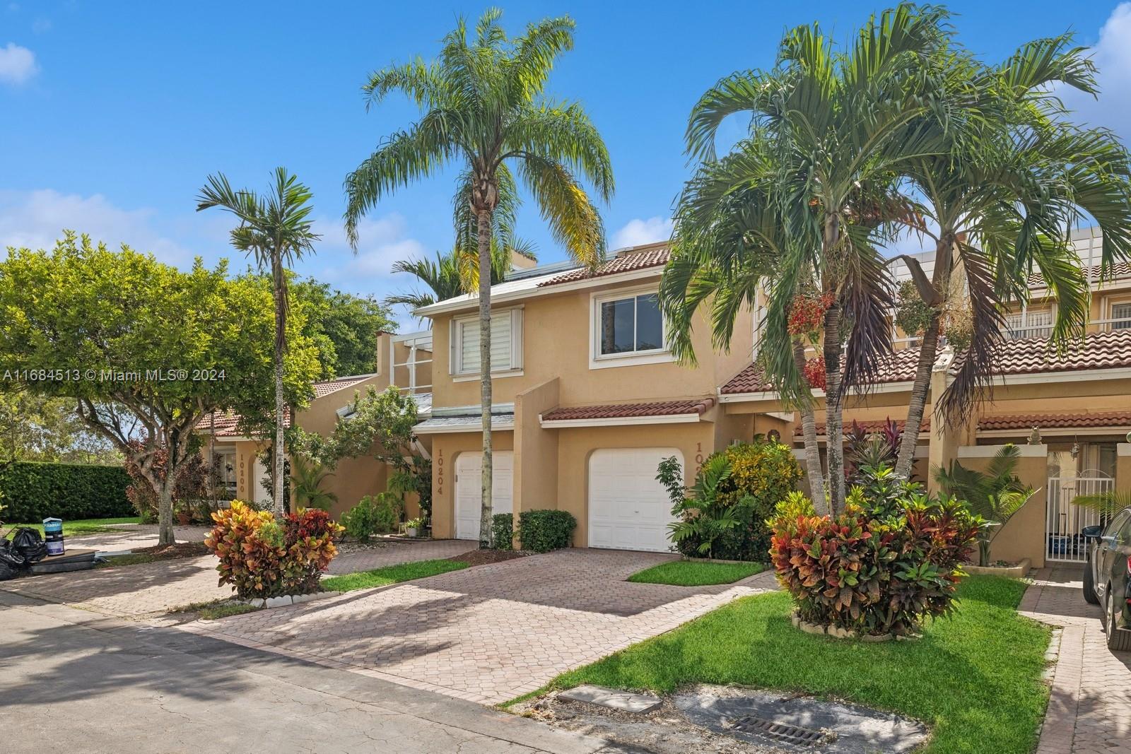 front view of a house with a yard and potted plants