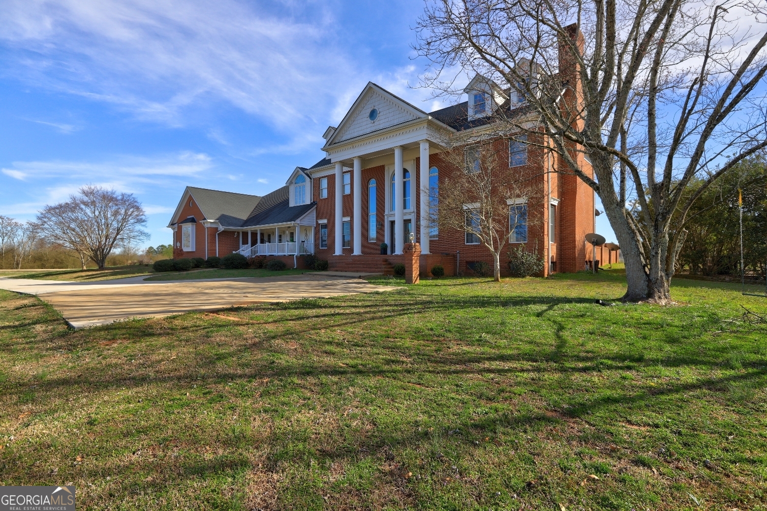 a view of a house with a big yard and large trees