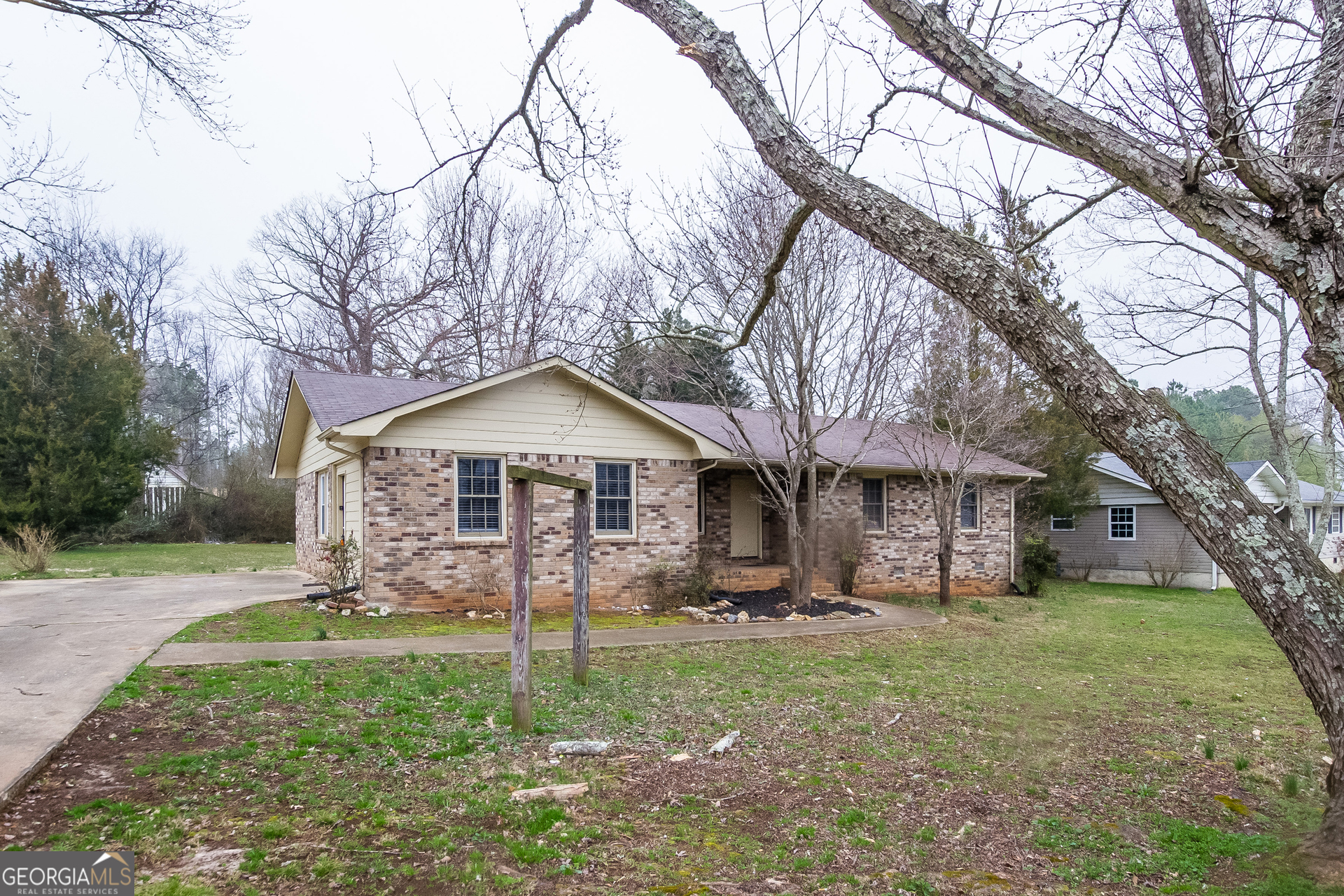 a view of a house with backyard and a tree