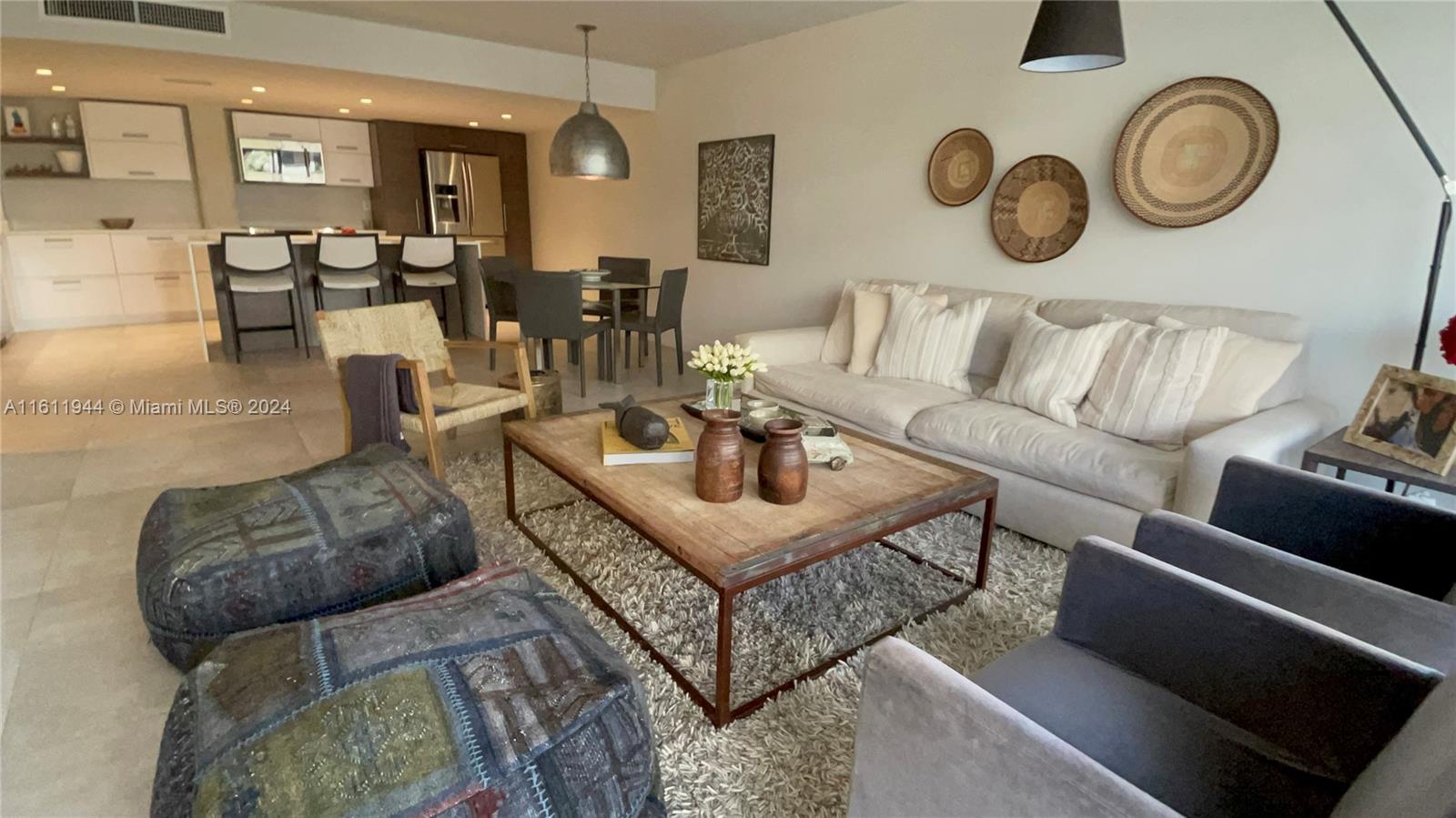 a living room with furniture a clock on wall and a window