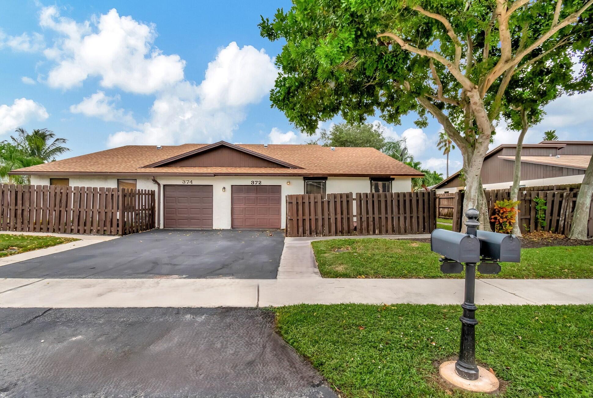 a front view of a house with a yard and trees