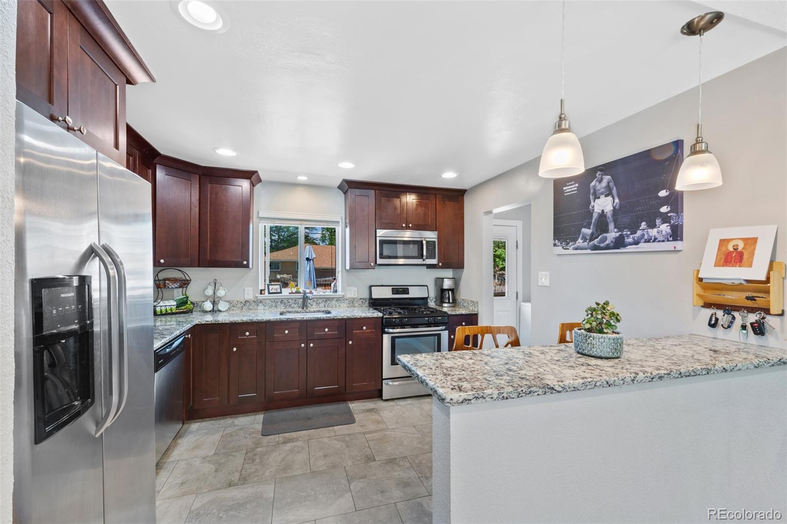 a kitchen with stainless steel appliances granite countertop a refrigerator and a sink