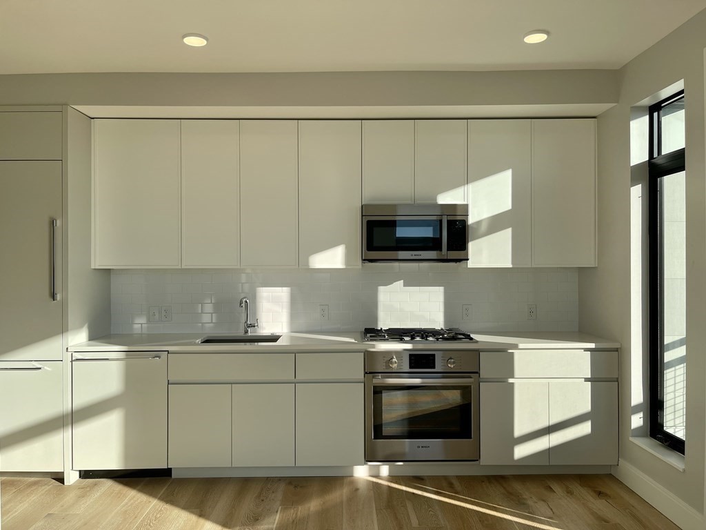 a kitchen with stainless steel appliances a sink stove and microwave