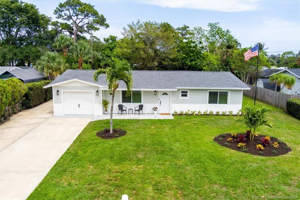 a front view of a house with a garden and trees