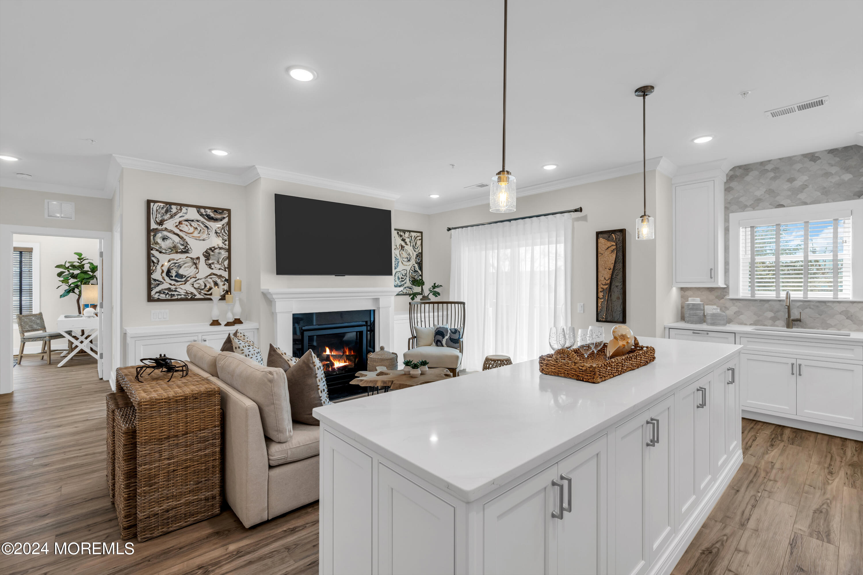 a living room with furniture a fireplace and a open kitchen view