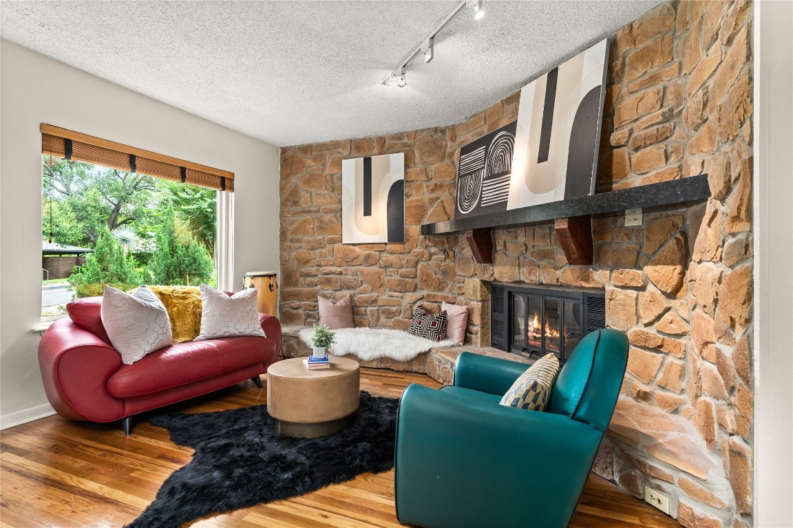 a living room with furniture fireplace and a large window