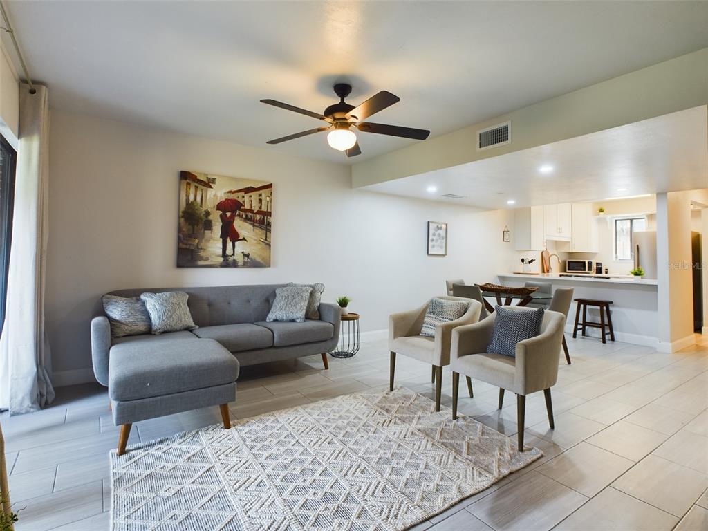 a living room with furniture and a view of kitchen