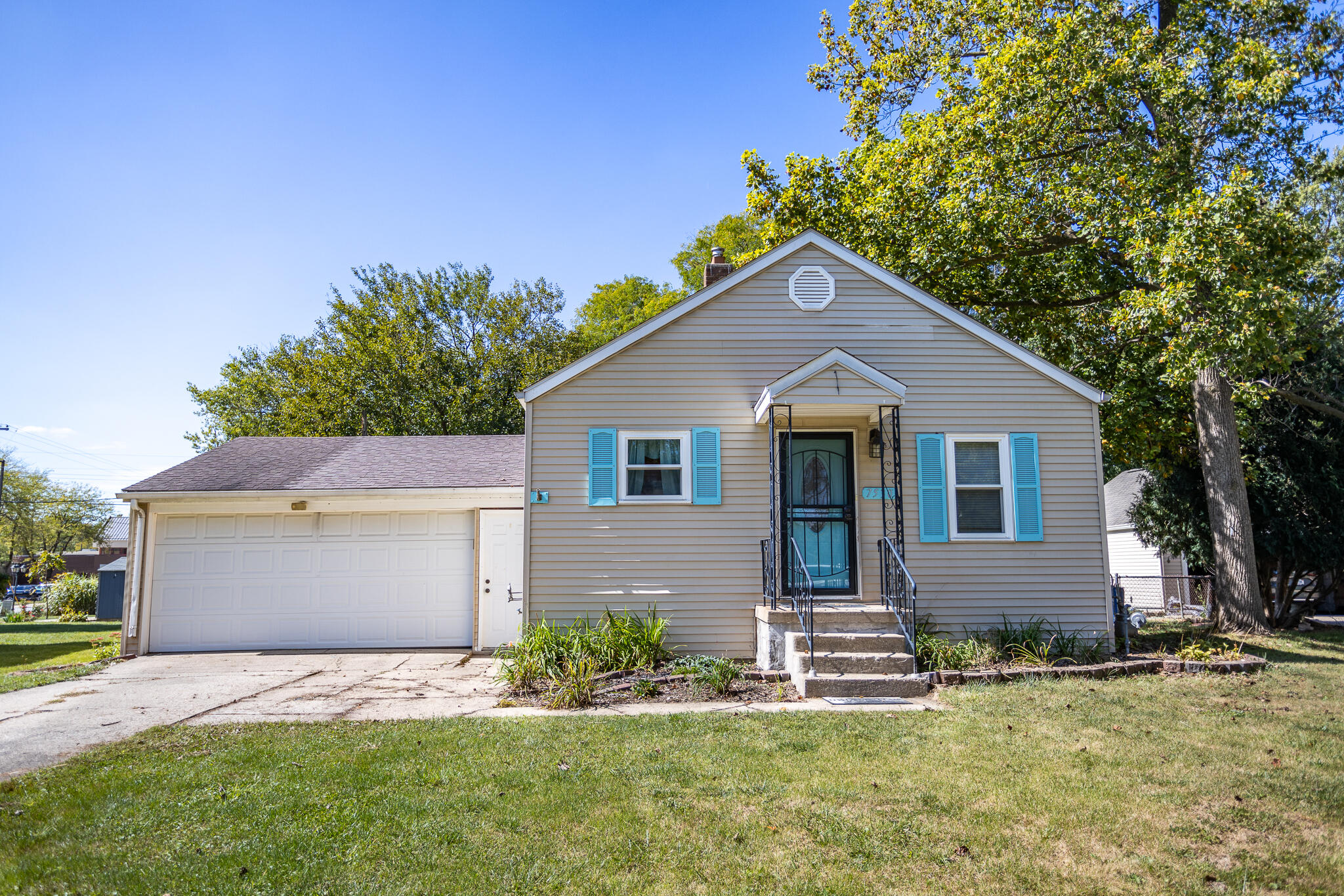 a front view of house with yard and trees in the background