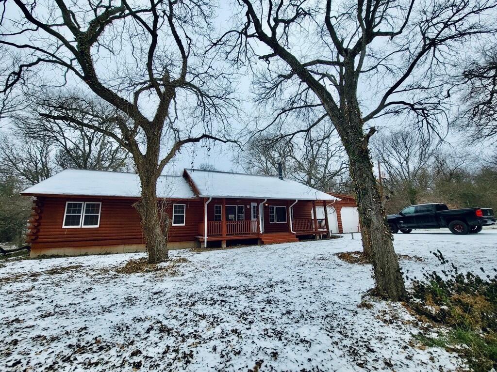 a view of a house with a yard tree and wooden fence