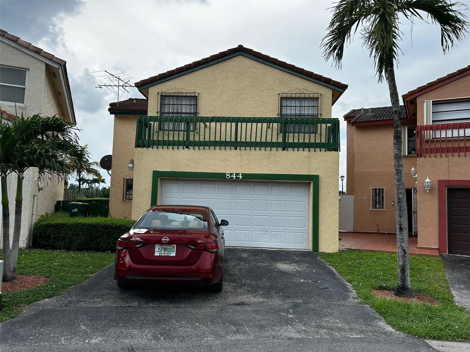 a front view of a house with a garden and plants