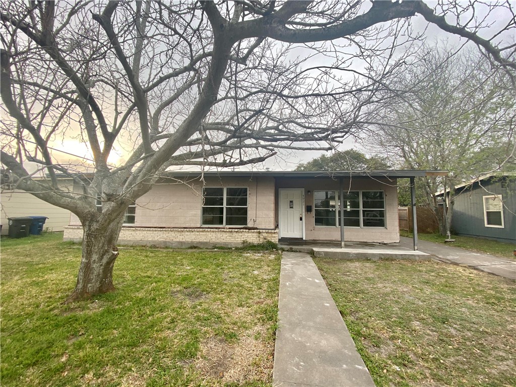 a front view of a house with a garden and trees