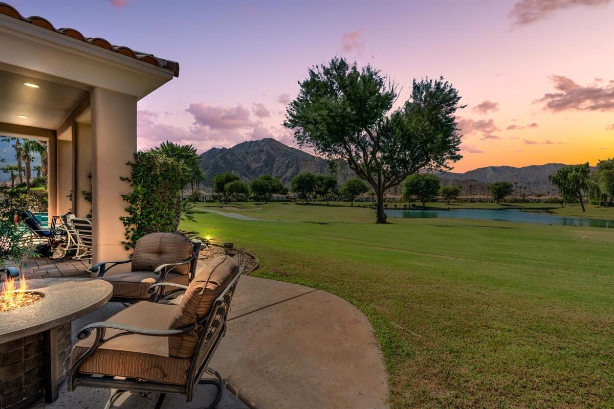 a view of a chairs and table in patio with a lake view