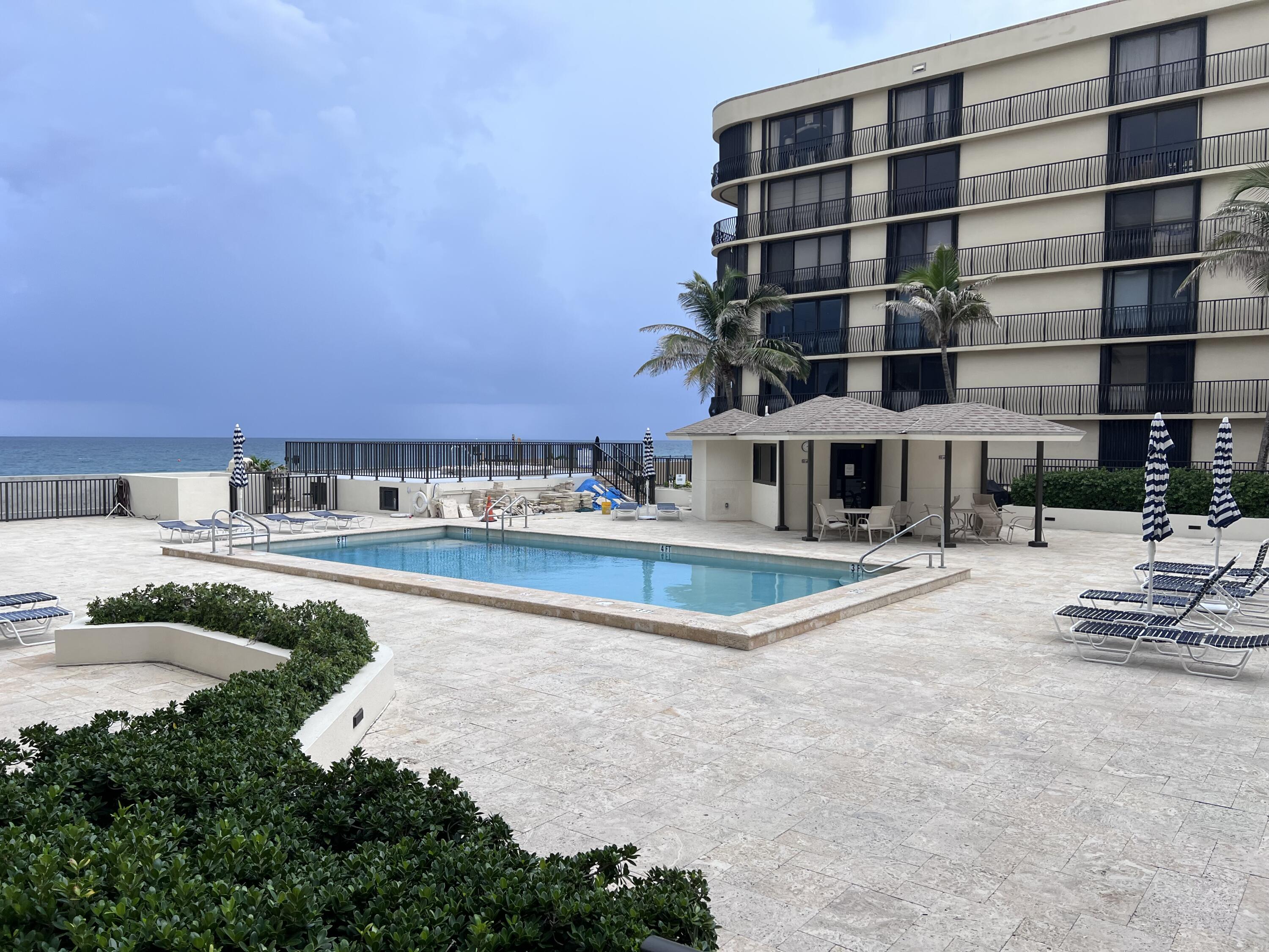 a view of pool with outdoor seating and house in the background