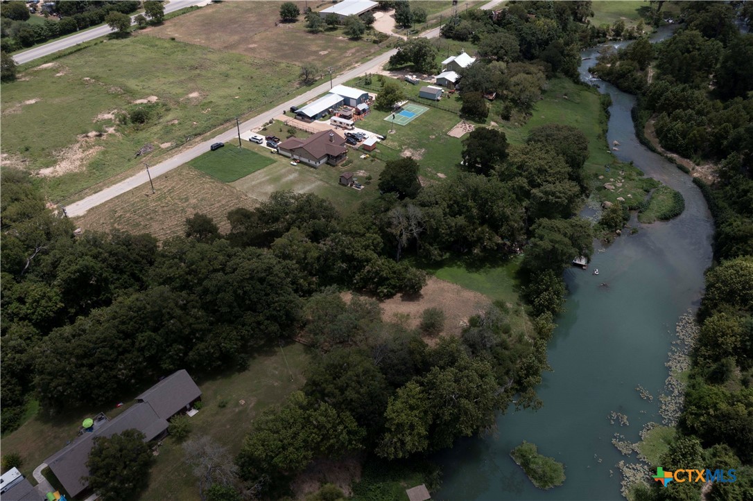 an aerial view of residential houses with outdoor space and trees