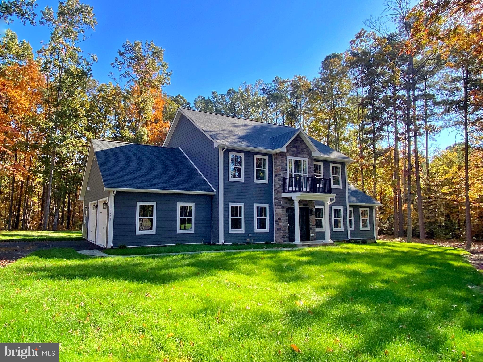 a view of a house with a yard and large trees