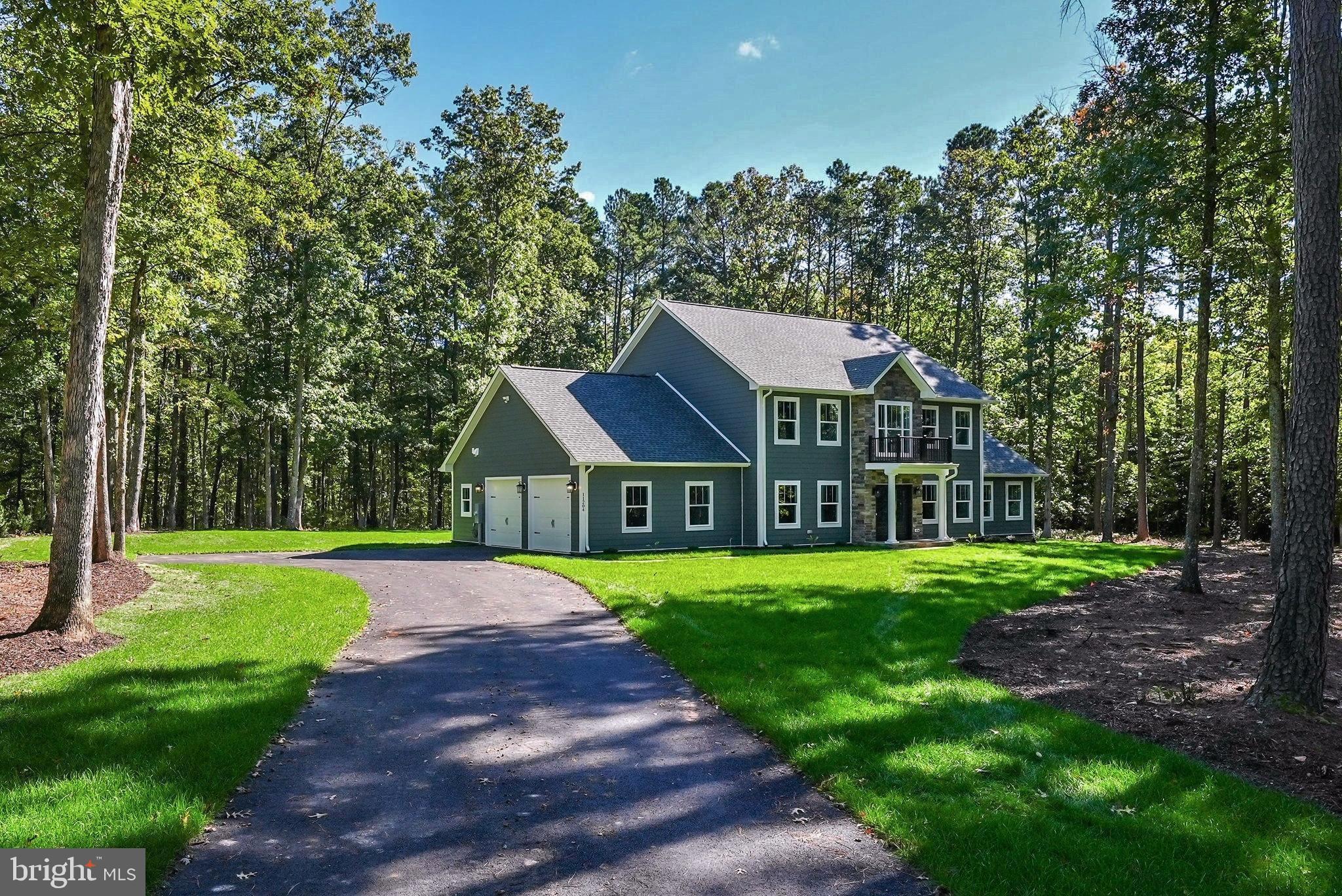 a front view of a house with a yard and trees