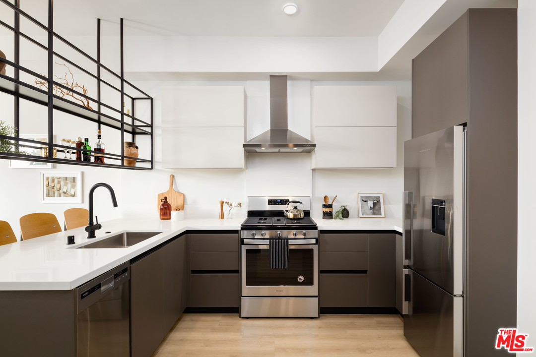 a kitchen with stainless steel appliances a sink stove and refrigerator