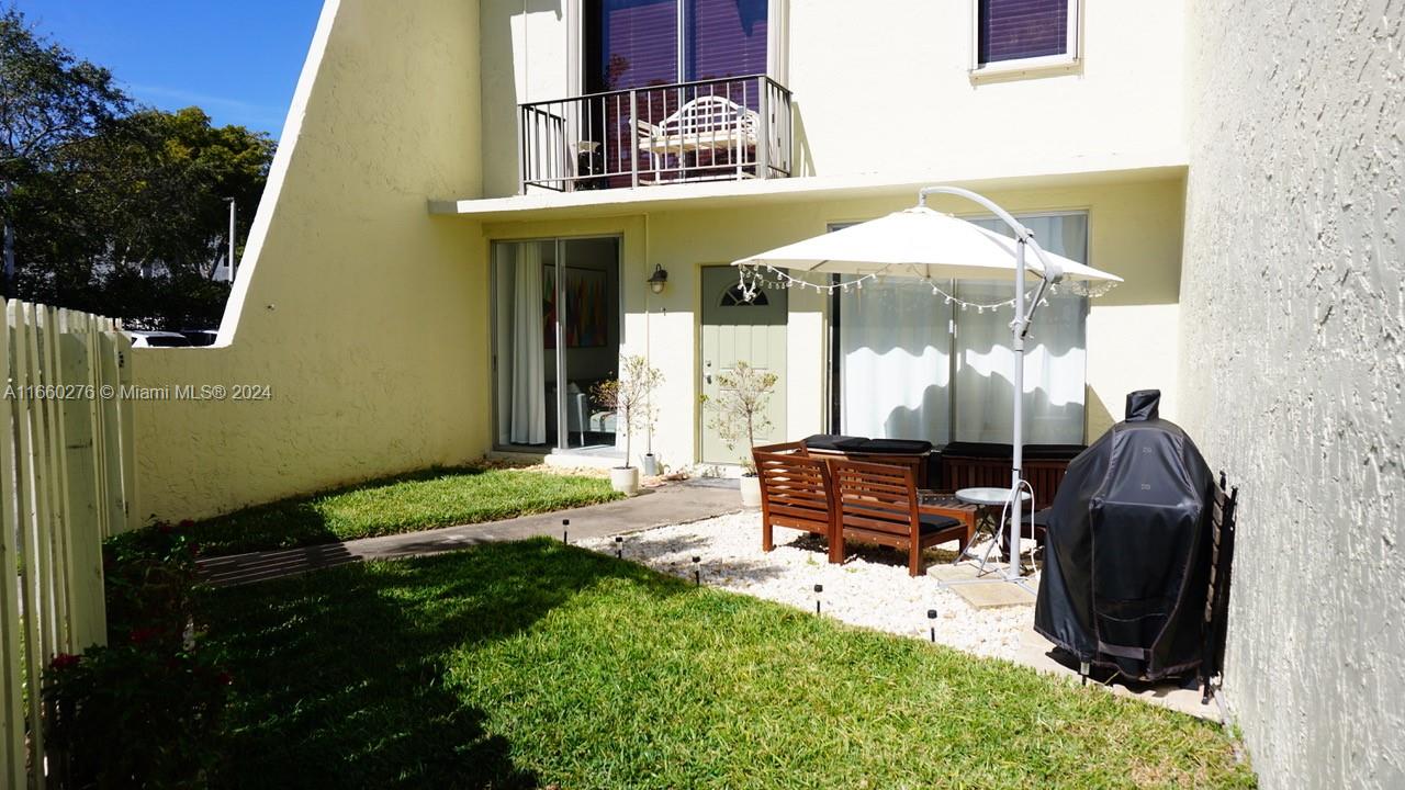 a view of a patio with table and chairs under an umbrella