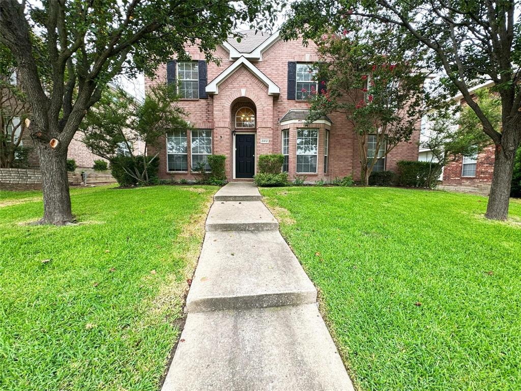 a front view of a house with a yard and garden