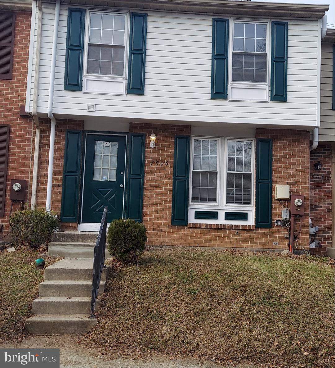 a front view of a brick house with a yard