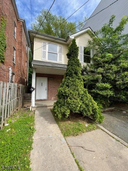 a front view of a house with a yard and potted plants