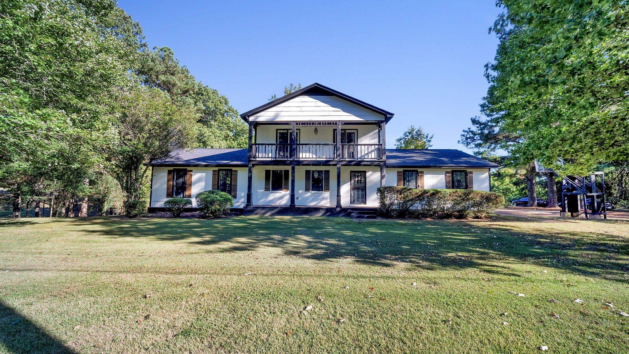 View of front of home with a balcony and a front yard