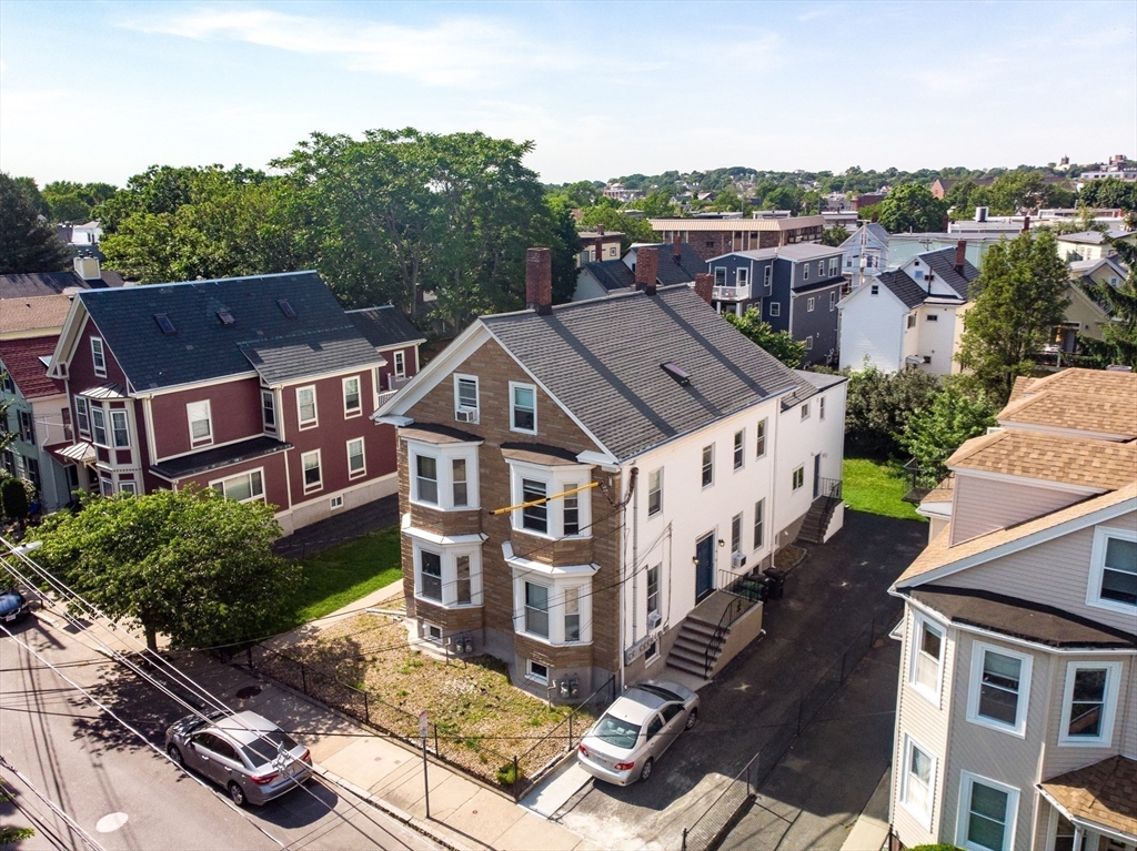 an aerial view of multiple houses with a yard