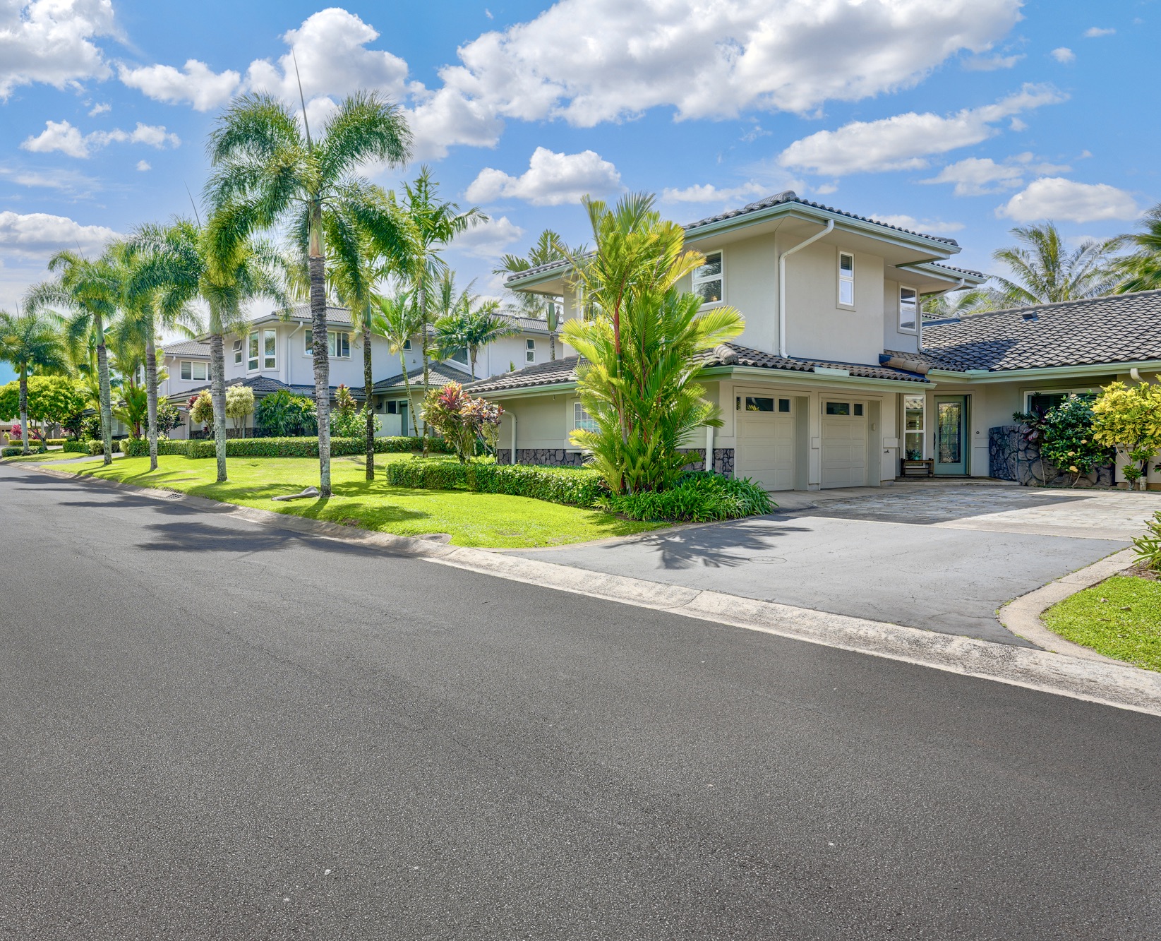 a view of a house with a yard and palm trees