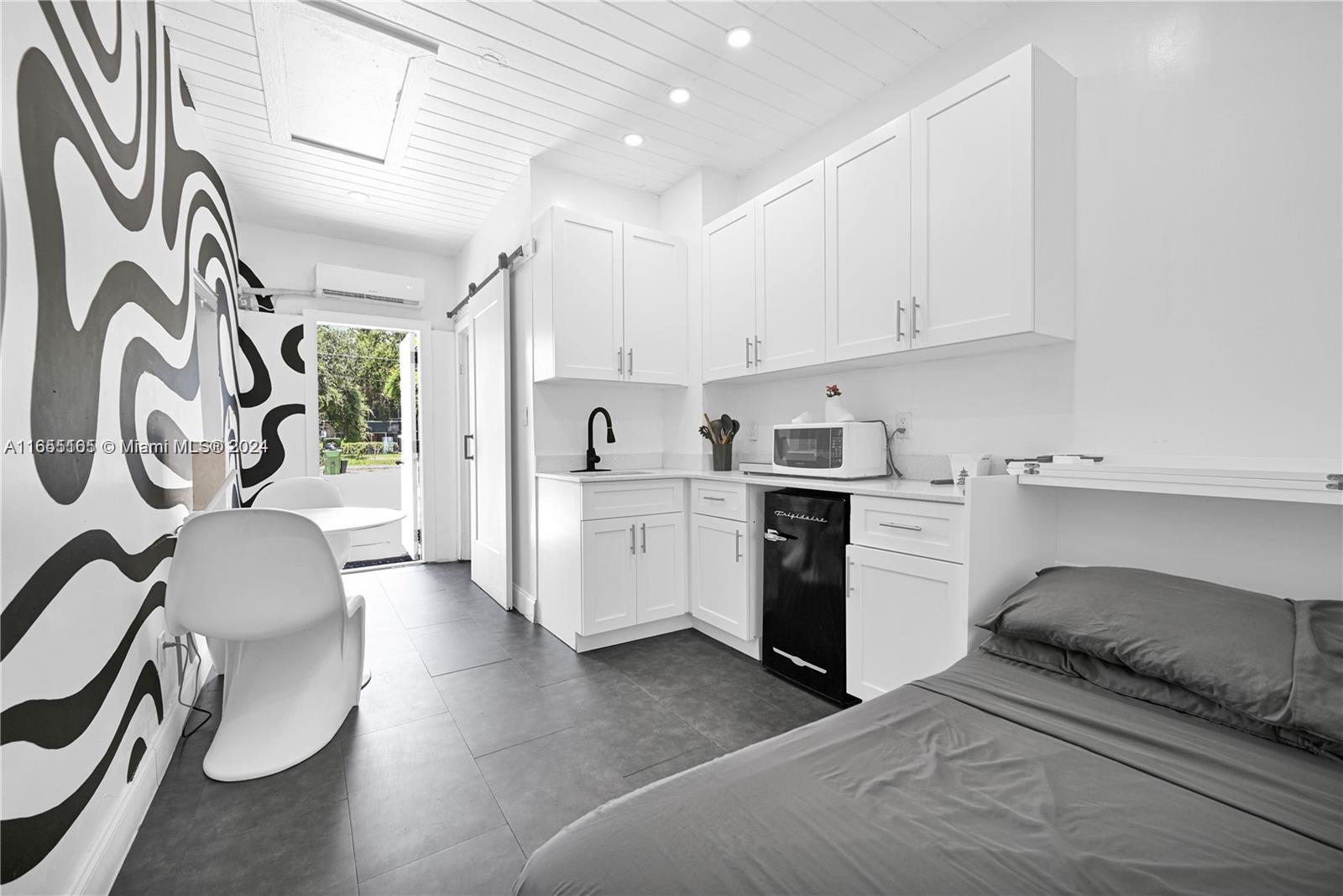 a kitchen with a white cabinets and wooden floor