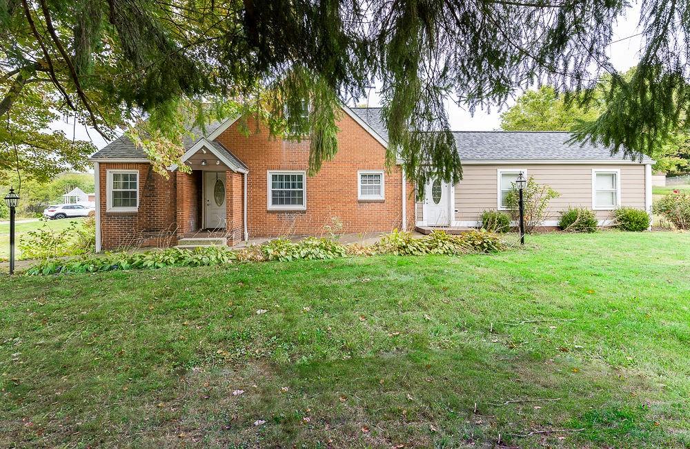 a front view of house with yard and green space