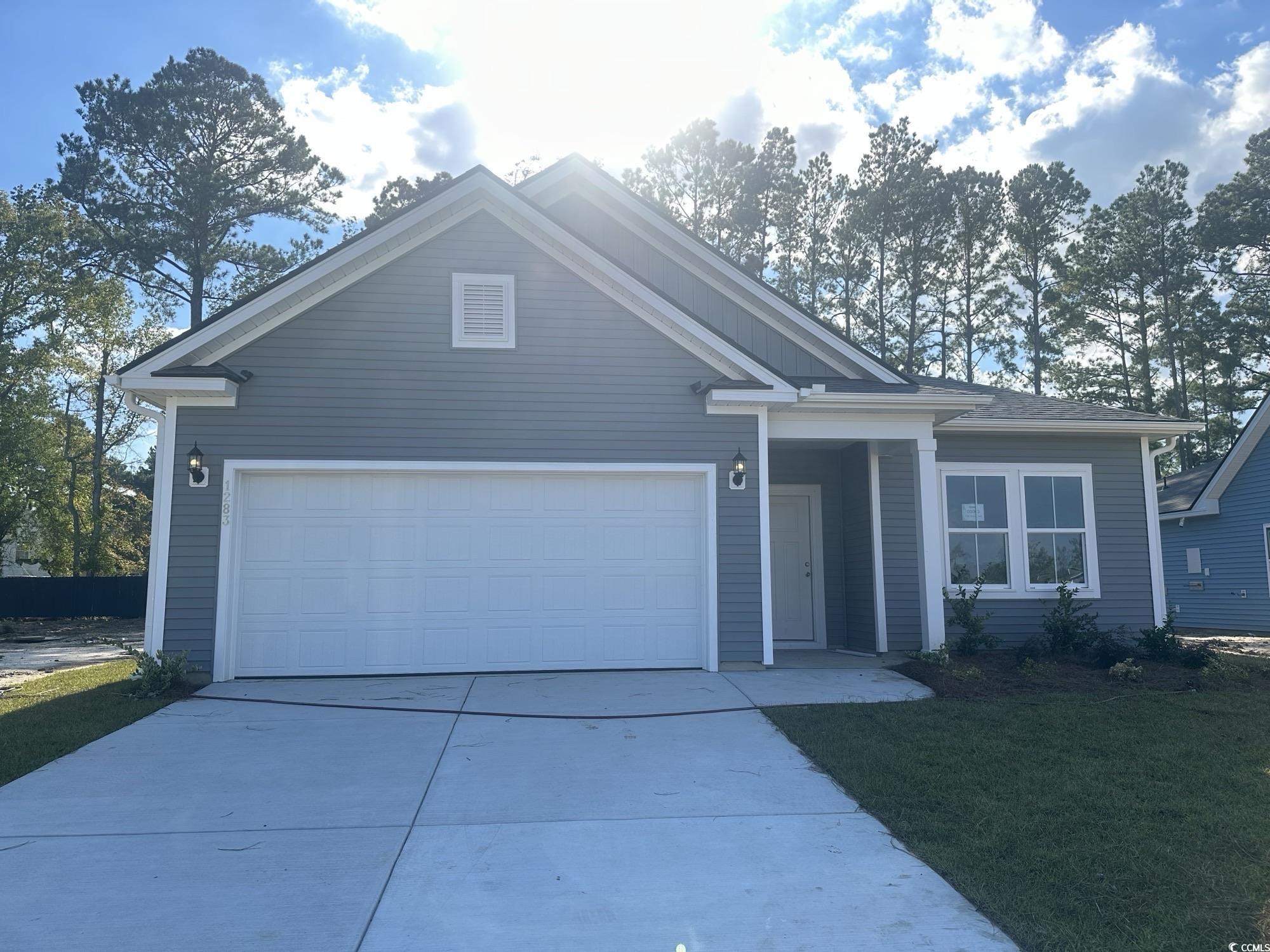 View of front of home with a front yard and a gara