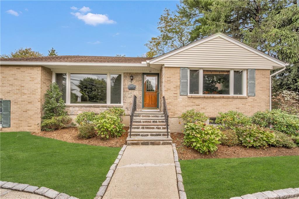 a front view of a house with a yard and potted plants