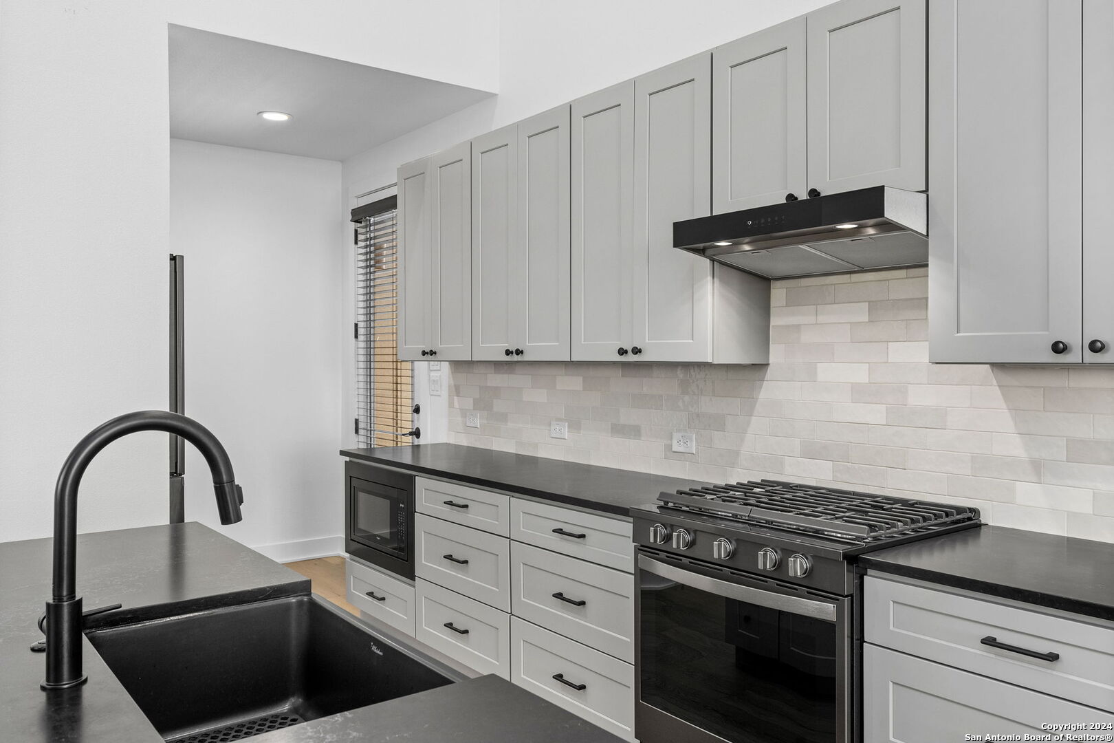 a kitchen with granite countertop a stove and a sink