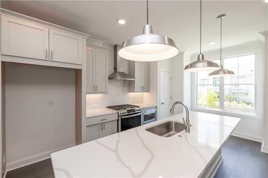 a kitchen with a stove a sink a window and cabinets