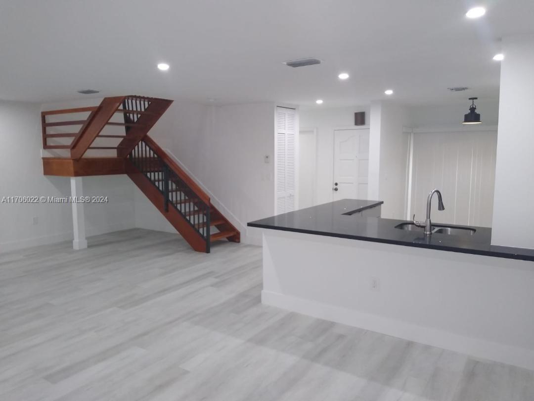 a hallway with stairs and wooden floor