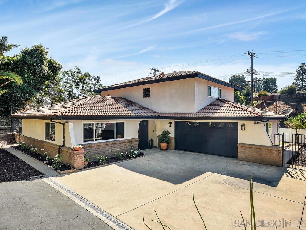 a front view of a house with yard and parking