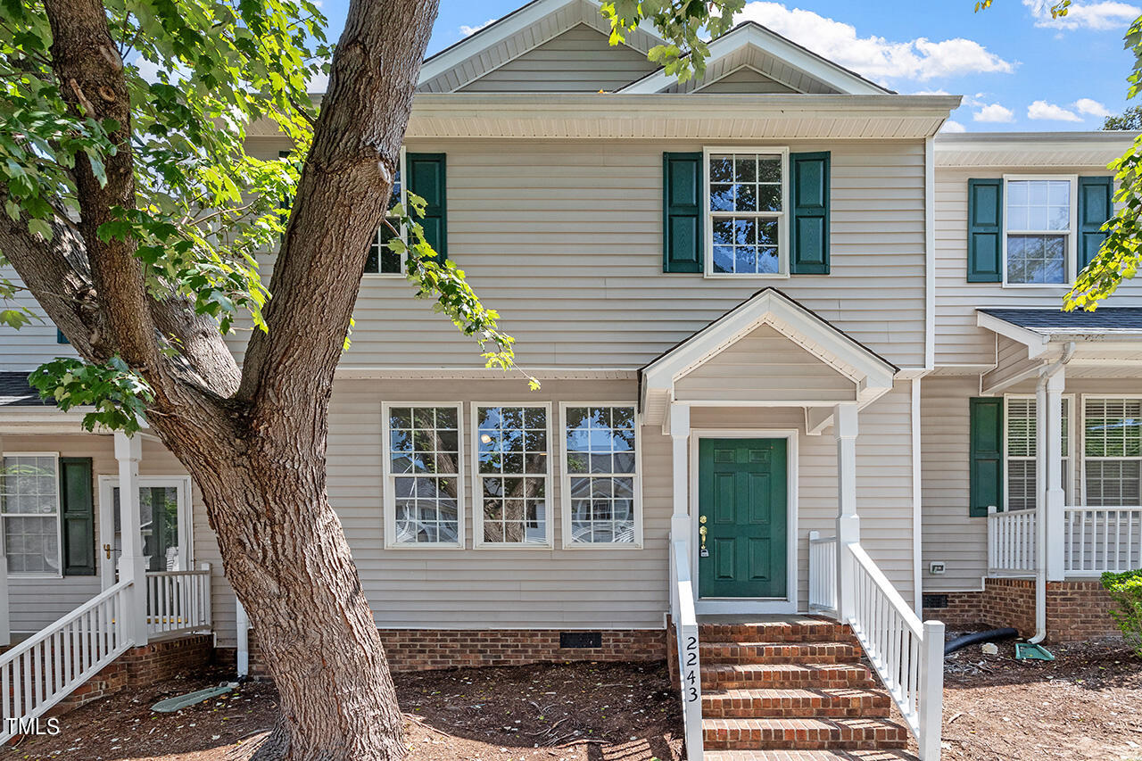 a front view of a house with a tree