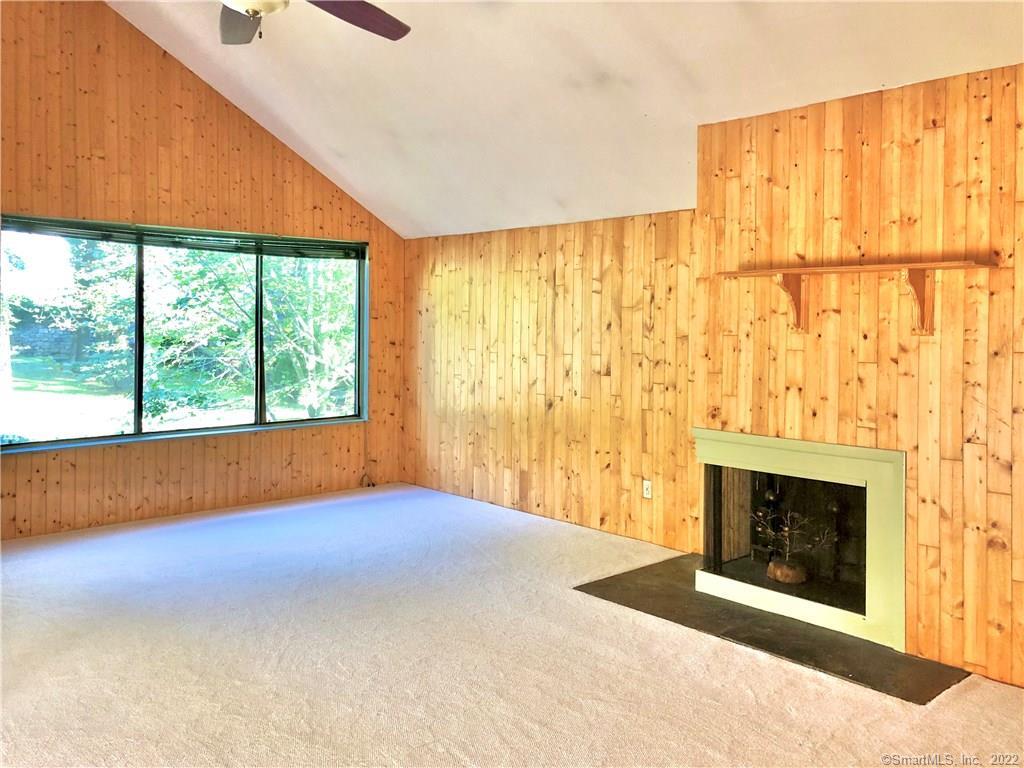 a view of an empty room with a fireplace and a window