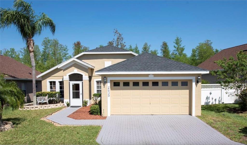 a front view of a house with a yard outdoor seating and garage