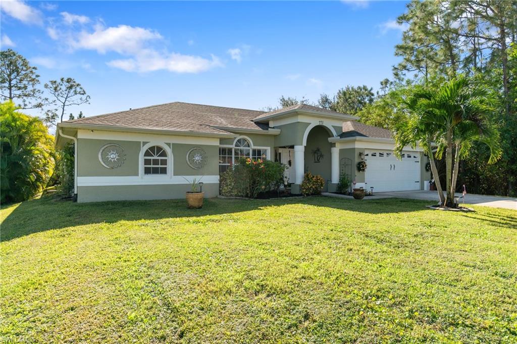 View of front of property featuring a front yard and a garage