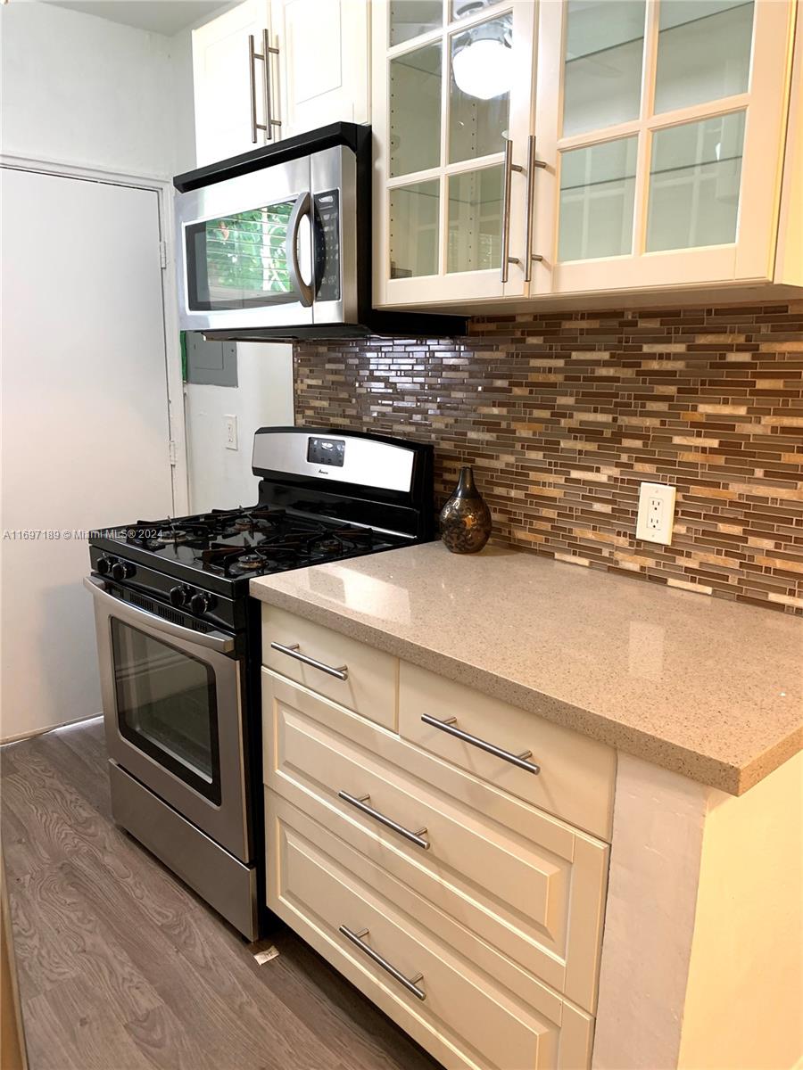 a kitchen with stainless steel appliances a stove and a microwave