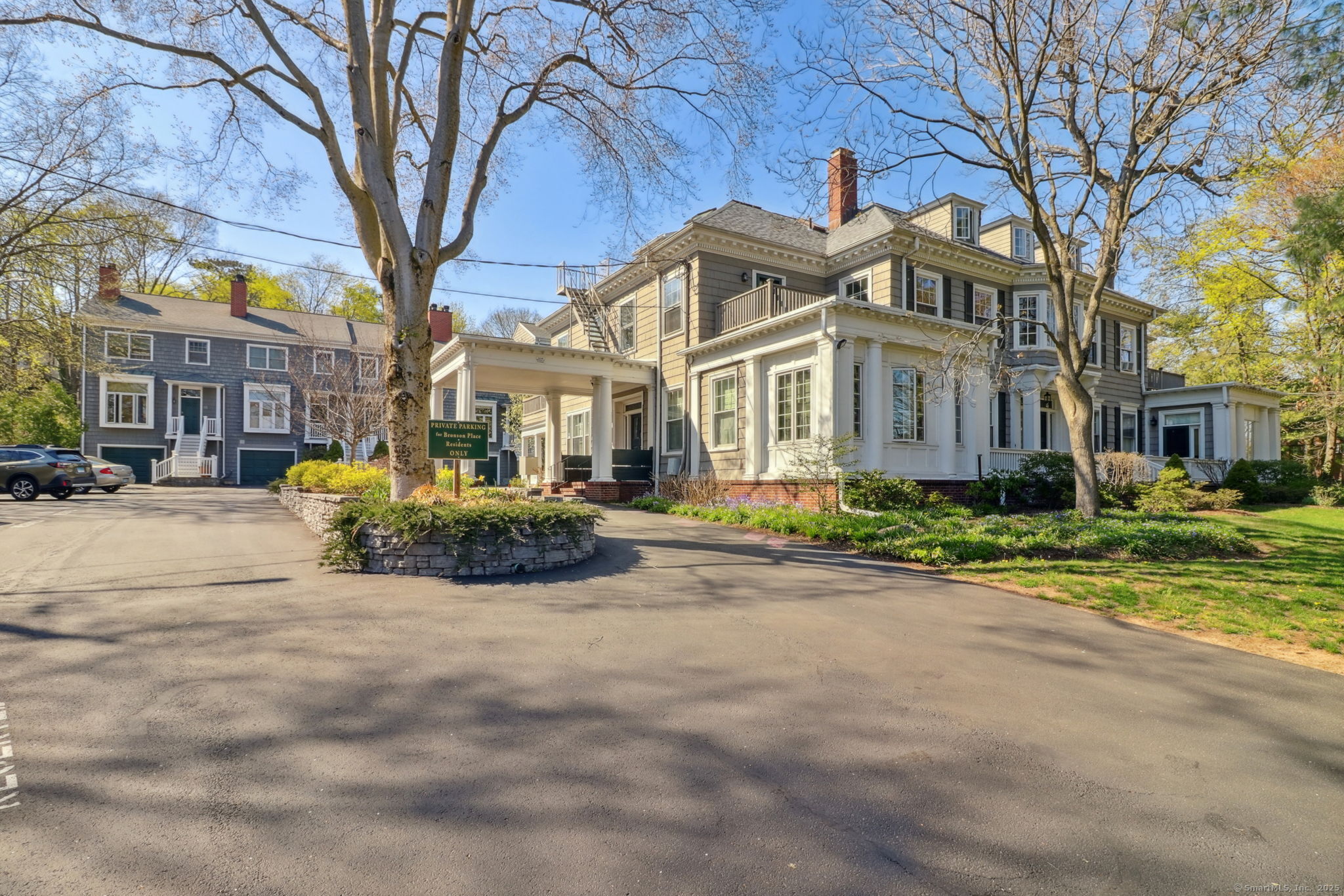 a view of a white house with a large trees and a yard