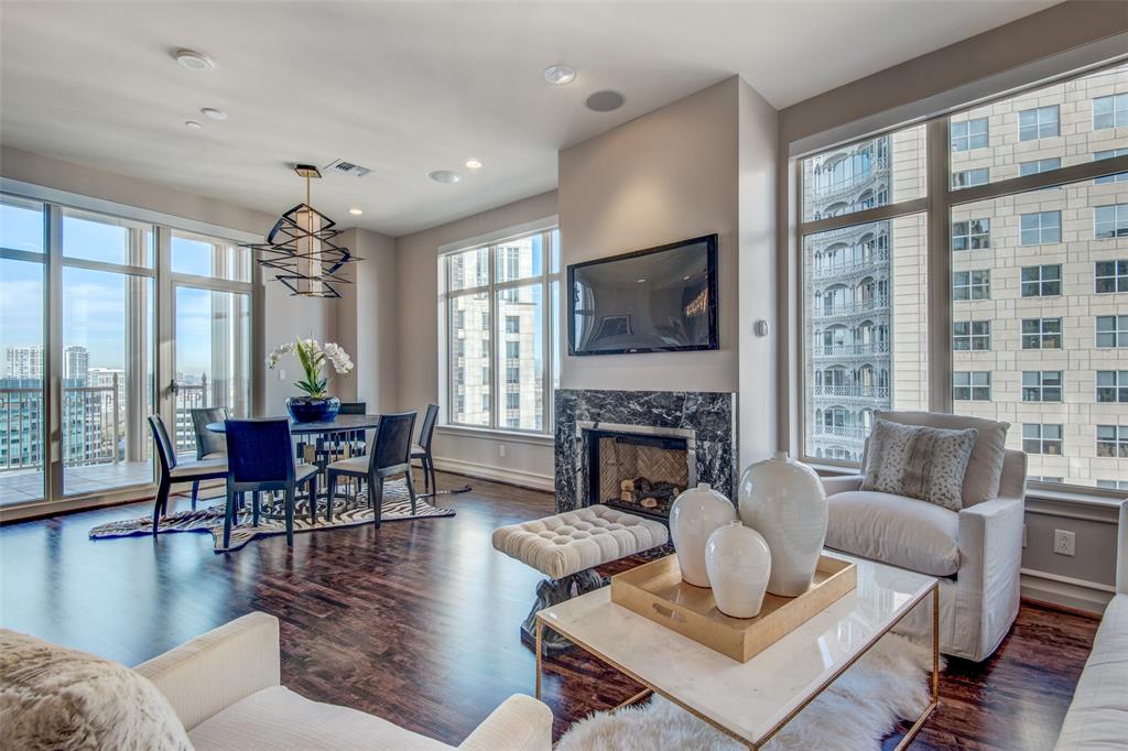 a living room with furniture a fireplace and a floor to ceiling window