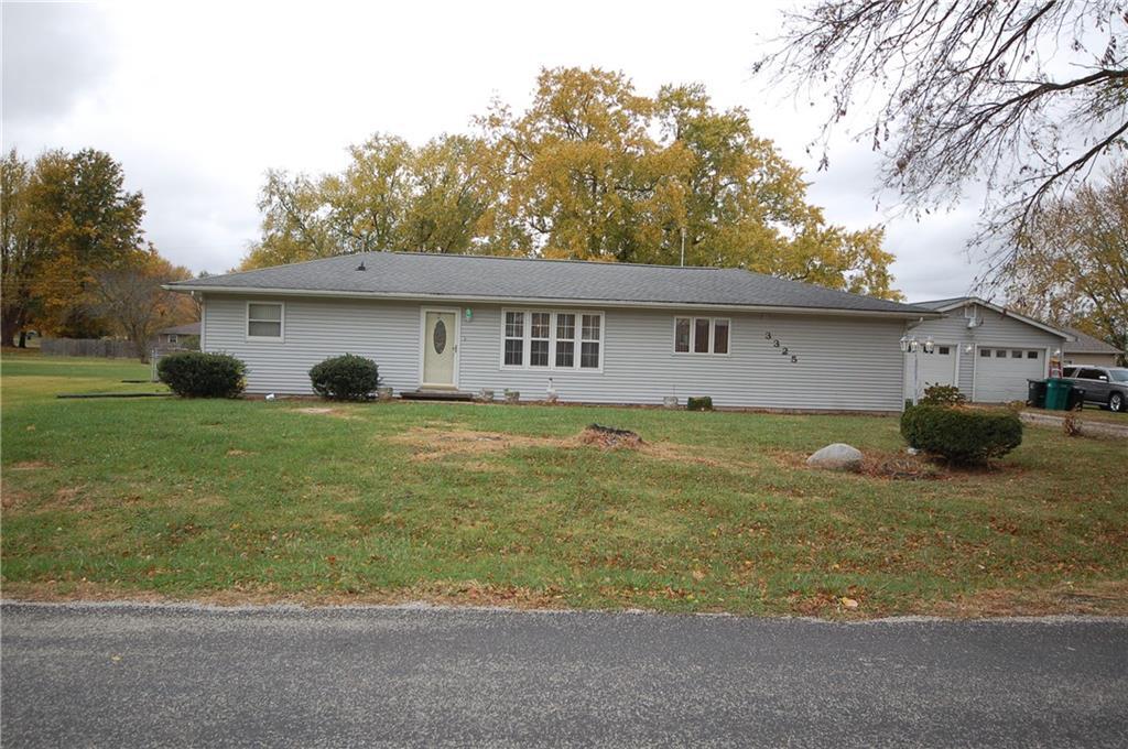 a front view of house with yard and trees in the background