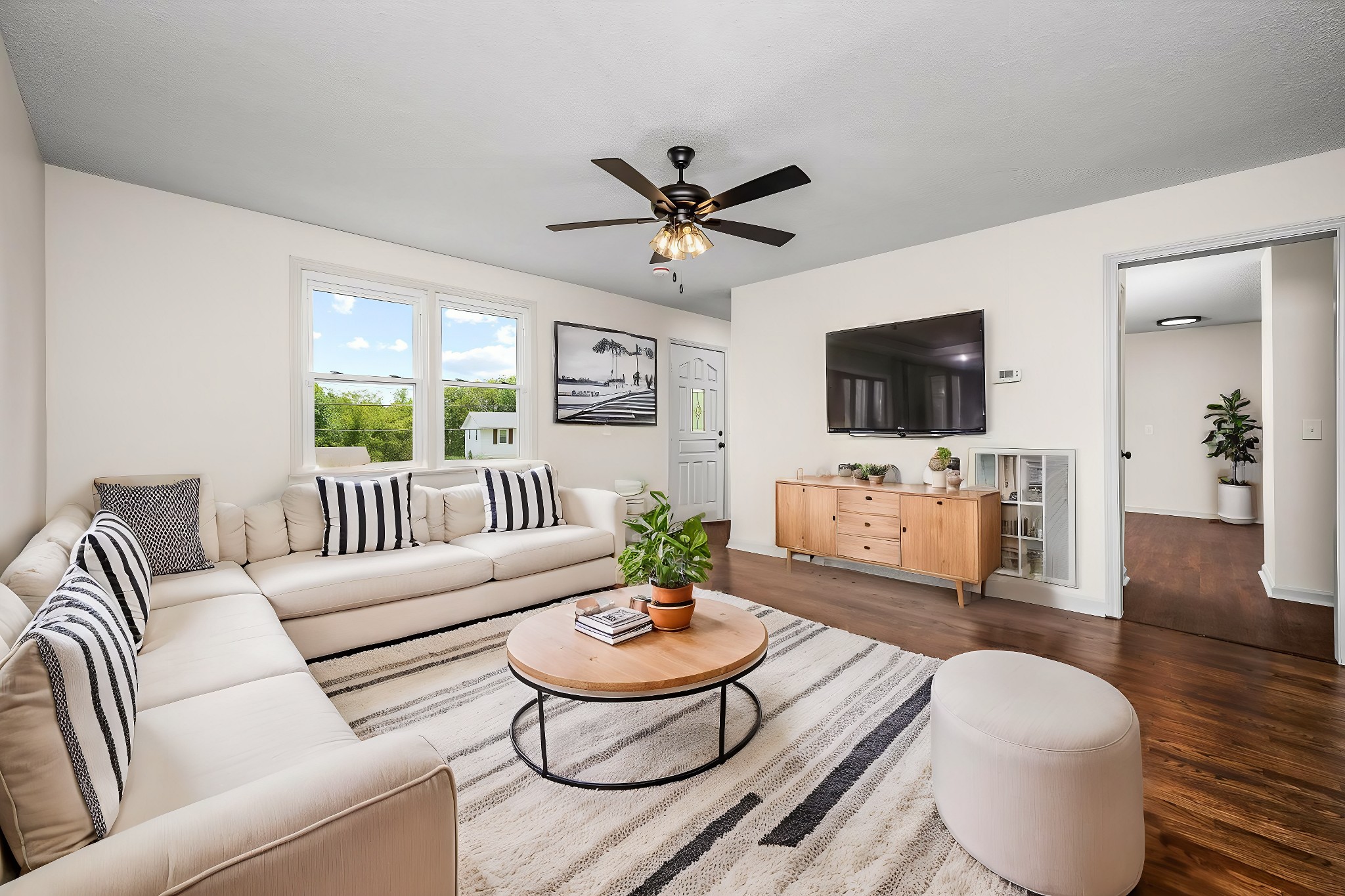 a living room with furniture a dining table and a flat screen tv