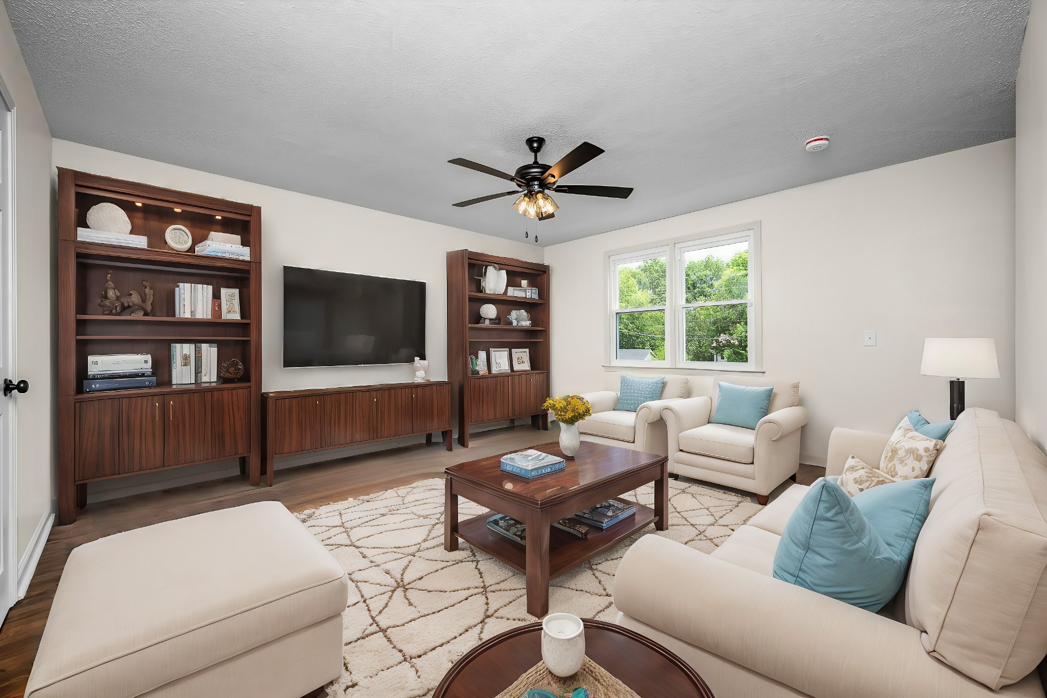 a living room with furniture a flat screen tv and a large window