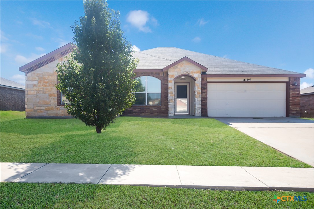 a front view of a house with a garden and yard