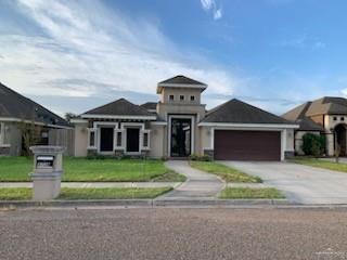 View of front of property featuring a front yard and a garage