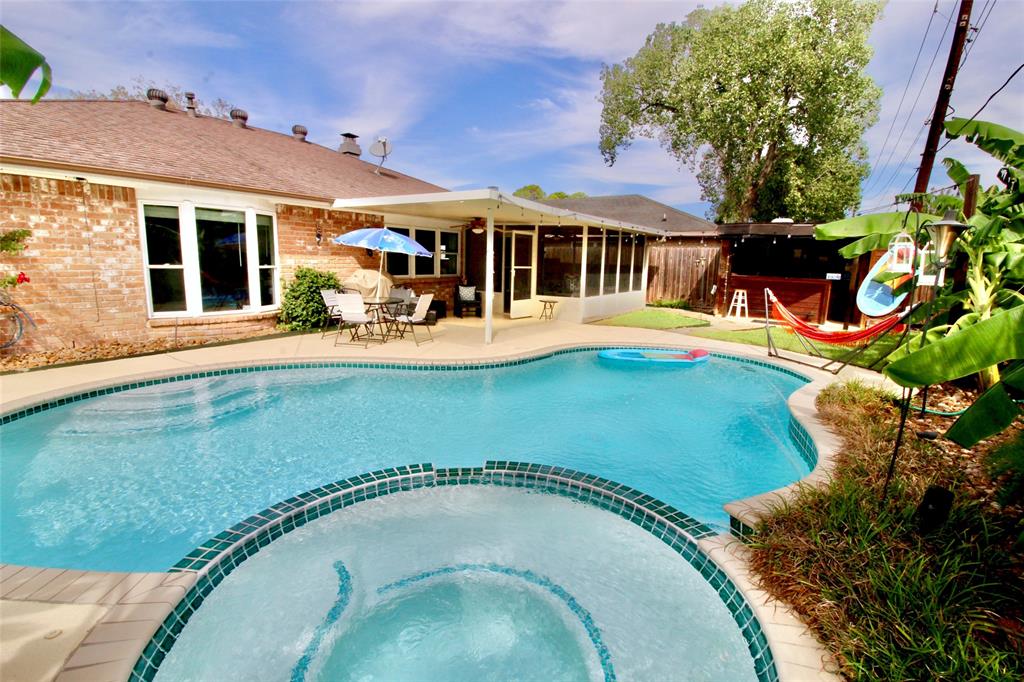 an outdoor view with swimming pool and glass windows and plants