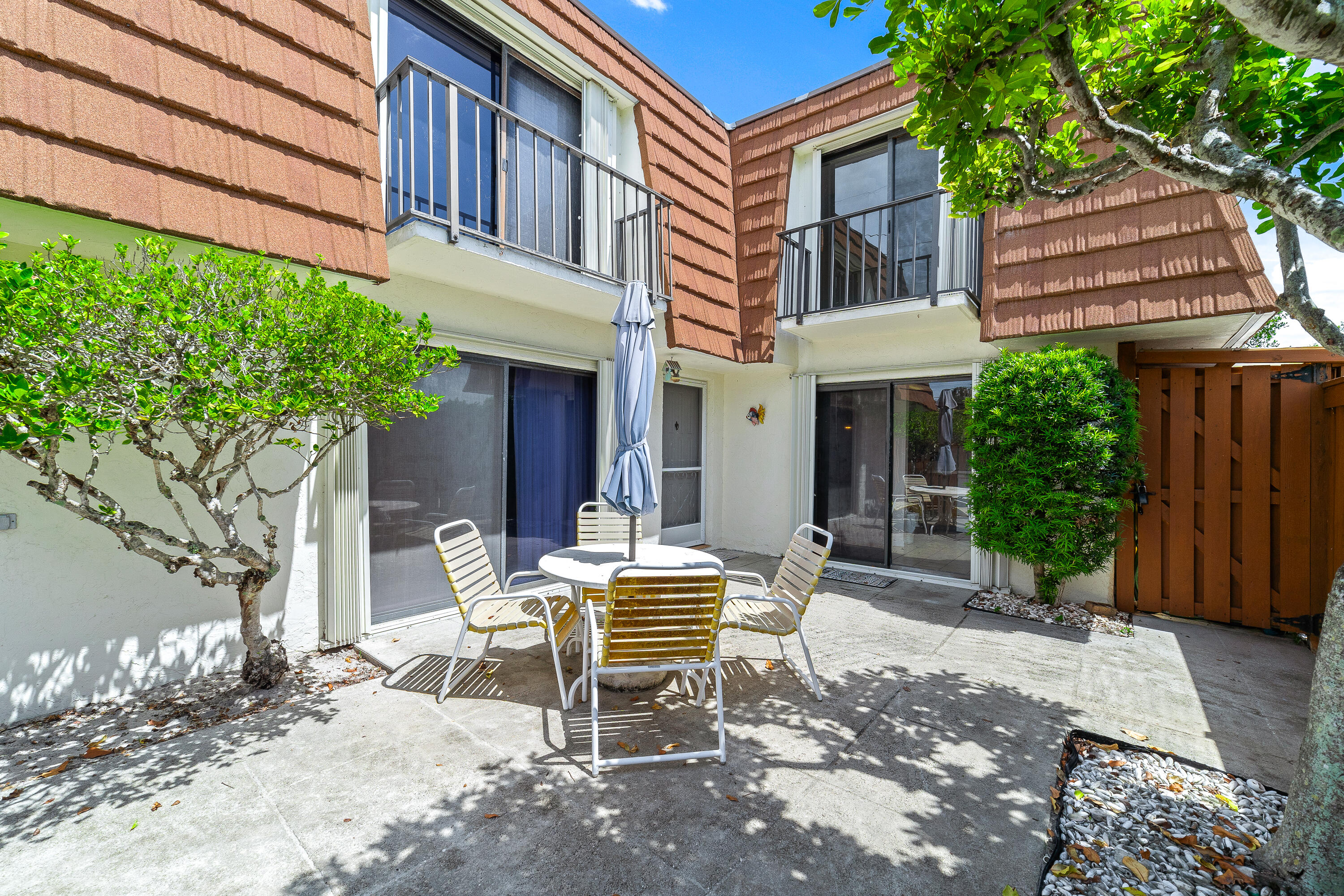 a backyard of a house with a bench and trees